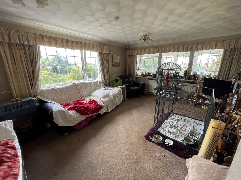 Lot: 148 - SEVEN-BEDROOM BUNGALOW WITH PERMISSION FOR TWO DETACHED DWELLINGS - Living room with fireplace